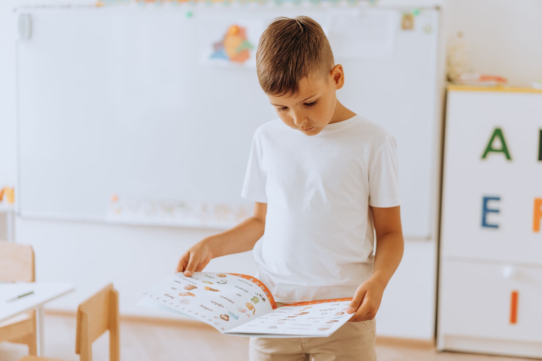 Representative image of a young boy reading in a classroom